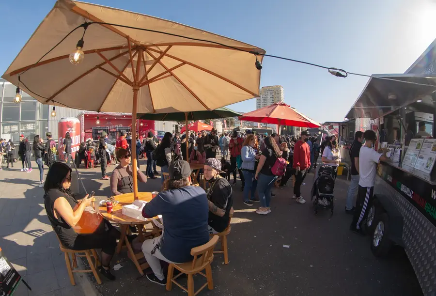 Patio de comidas con foodtrucks y público en el evento